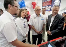  ??  ?? (Front, from right) Aminuddin, Yii and Unyang listening to a briefing on the online service by an EPF officer.