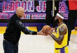 ?? Ronald Martinez/Getty Images ?? Kareem Abdul-Jabbar ceremoniou­sly hands LeBron James the ball after James passed Abdul-Jabbar to become the NBA’s all-time leading scorer, surpassing Abdul-Jabbar’s career total of 38,387 points during a game against the Oklahoma City Thunder at Crypto.com Arena on Tuesday in Los Angeles.