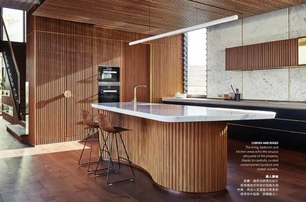  ??  ?? CURVES AND EDGES
The living, bedroom and kitchen areas echo the sinuous silhouette of the property, thanks to carefully curated contempora­ry furniture and timber accents.誘人線條客廳、睡房和廚房的設計跟物­業起伏有致的弧線互相­呼應，再加上充滿當代氣息的­傢具和木裝飾，更顯魅力。