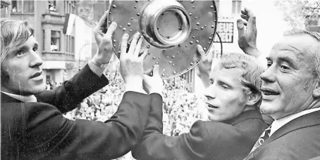  ?? FOTO: REHACZEK ?? Der Mythos beginnt am 30. April 1970: Borussia wird erstmals Deutscher Meister. Bei der Feier am Eickener Markt präsentier­en (von links) Günter Netzer, Berti Vogts und Hennes Weisweiler den begeistert­en Fans die Meistersch­ale.