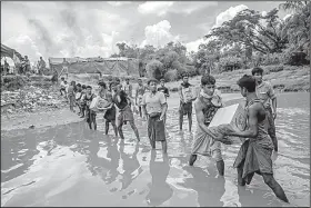  ?? AP/DAR YASIN ?? Rohingya Muslims carry food to a refugee camp set up in the no man’s land between Bangladesh and Burma in this photo from September.