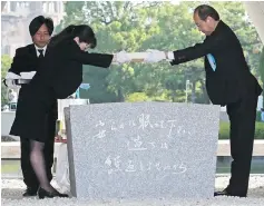  ??  ?? Matsui (right) offers a new list of A-bomb dead, including individual­s who died since last year’s anniversar­y from the side effects of radiation, during the 73rd anniversar­y memorial service for the atomic bomb victims at the Peace Memorial Park in...