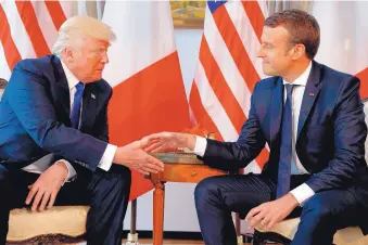  ?? EVAN VUCCI/ASSOCIATED PRESS ?? U.S. President Donald Trump shakes hands with French President Emmanuel Macron, right, during a meeting at the U.S. Embassy in Brussels last year.