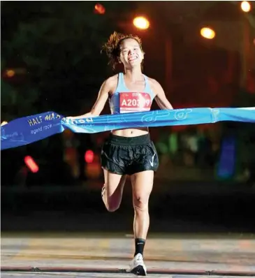  ?? Photo of Vũ Media ?? FIRST PAST THE POST: Phạm Thị Hồng Lệ crosses the finish line of the Tây Hồ Half Marathon 2024's women's 21km class yesterday.