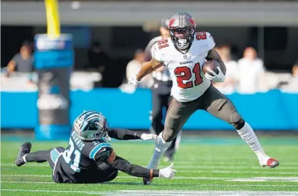  ?? TILTON/GETTY JARED C. ?? Buccaneers RB Ke’Shawn Vaughn avoids a tackle from Carolina’s Juston Burris en route to a 55-yard TD run in the first quarter on Sunday.