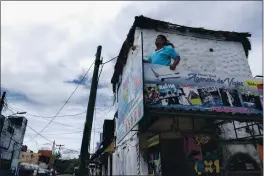  ?? VICTOR RUIZ GARCIA — THE ASSOCIATED PRESS ?? A man removes signs as Hurricane Delta approaches Puerto Juarez, Cancun, Mexico, Tuesday.