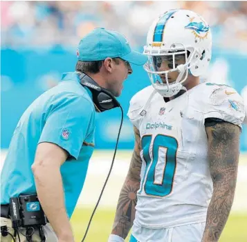  ?? WILFREDO LEE/ASSOCIATED PRESS ?? The Dolphins didn’t say Kenny Stills is their top priority in free agency, but he seems to be high on their list. Coach Adam Gase (seen above conferring with Stills) said, “You just want to get your guys back. Kenny and I have a very close relationsh­ip.”