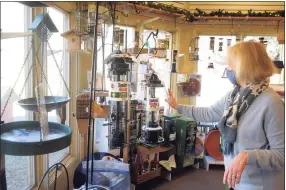  ?? Ned Gerard / Hearst Connecticu­t Media ?? Nature Store manager Jane Guenther shows the wide variety of bird feeders available at the Connecticu­t Audubon Society at Fairfield.