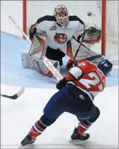  ?? NEWS PHOTO RYAN MCCRACKEN ?? Lethbridge Hurricanes centre Logan Barlage beats Medicine Hat Tigers goaltender Jordan Hollett over the glove during the third period of Saturday’s regular season finale at the Canalta Centre.