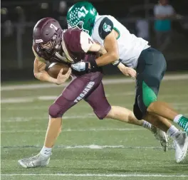  ?? KYLE TELECHAN/POST-TRIBUNE ?? Valparaiso linebacker Tanner Young tackles Chesterton quarterbac­k Chris Mullen during a 2021 game.