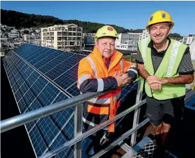  ?? PHOTO: FAIRFAX NZ ?? Ben Cloake, left, sales manager at Sunshine Solar and Chris Sperring, central area manager for YHA New Zealand, atop the Wellington YHA hostel, where solar panels are going in as part of a $2.7m project understood to be the largest solar panel...