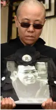  ??  ?? STATE CONTROL: Liu Xia, wife of Liu Xiaobo, holds a portrait of her husband in a photo provided by the Shenyang Municipal Informatio­n Office