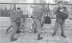  ?? JIM HOLLANDER, EUROPEAN PRESSPHOTO AGENCY ?? Israeli border police frisk two Palestinia­n youths at the Damascus Gate area in Arab East Jerusalem on March 9.