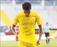  ?? Lars Baron / Pool / AFP via Getty Images ?? Borussia Dortmund’s English midfielder Jadon Sancho shows a “Justice for George Floyd” shirt as he celebrates after scoring against Paderborn in a Bundesliga match Sunday.