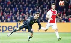  ?? — Reuters photo ?? Ronaldo (left) scores their first goal during the UEFA Champions League first leg quarterfin­al match between Ajax Amsterdam and Juventus FC at the Johan Cruijff ArenA in Amsterdam.