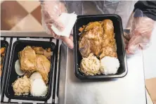  ?? Photos by Nick Otto / Special to The Chronicle ?? Top: Stephen Ngan and Ho Take Fu deliver meals to senior citizens living at The Lady Shaw Senior Center in San Francisco. Above: Chicken and rice was on the menu.