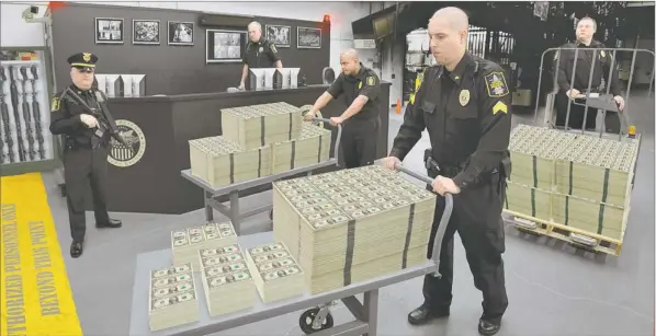  ??  ?? 48-HOUR DISTRIBUTI­ON: These seldom seen full uncut sheets of new $1 bills are being moved from the private vaults of the World Reserve Monetary Exchange for immediate distributi­on to state residents. Residents who beat the 48-hour order deadline to get...