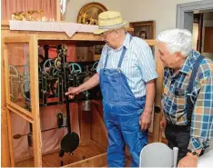  ??  ?? Das alte Uhrwerk der Kirchturmu­hr ist immer noch funktionsf­ähig und befindet sich im Pfarrheim. Die Holzeinfas­sung hat natürlich der „Wanger Schorsch“gefertigt. Rechts daneben: Anton Welzhofer senior.