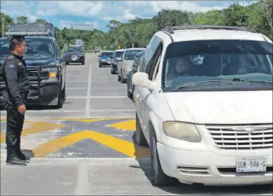  ?? ?? Un policía vigila el tránsito de los vehículos que pasan por uno de los cuatro reductores de velocidad que se hicieron en la vía a Chichimilá