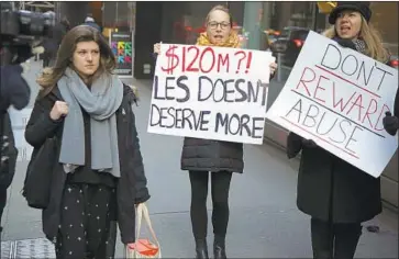  ?? Seth Wenig Associated Press ?? WOMEN protest near CBS’ shareholde­rs meeting in New York on Tuesday. The board will determine whether CEO Leslie Moonves was fired for cause, which would deny him the remaining $120 million of his severance.