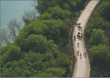  ?? (AP/Julio Cortez) ?? Migrants walk on a dirt road after crossing the U.S.-Mexico border in Mission, Texas.