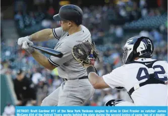  ?? — AFP ?? DETROIT: Brett Gardner #11 of the New York Yankees singles to drive in Clint Fraxier as catcher James McCann #34 of the Detroit Tigers works behind the plate during the second inning of game two of a doublehead­er at Comerica Park on Monday in Detroit.