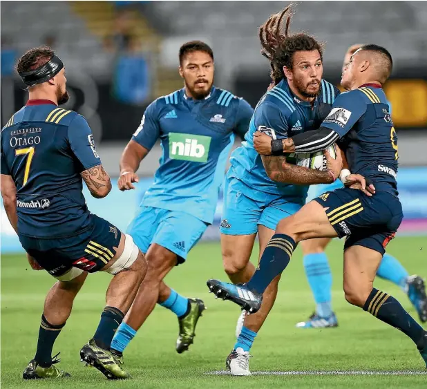  ??  ?? Rene Ranger, of the Blues, has his progress halted by Highlander­s halfback Aaron Smith at Eden Park last night.