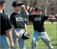  ?? MEDIANEWS GROUP FILE PHOTO ?? Julian Morton (center) and teammates toss balls as they warm up after the Towamencin Youth Associatio­n Little League Opening Day Ceremony at Bustard Road Park on Saturday April 12, 2014.