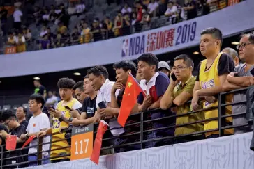  ??  ?? Photo ci-dessus :
Lors d’un match d’exhibition de la Ligue américaine de basketball, le 12 octobre 2019 à Shenzhen (Sud de la Chine), des fans chinois arborent le drapeau national, en soutien à leur gouverneme­nt dans la crise qui l’oppose à la NBA depuis qu’un dirigeant de l’équipe des Houston Rockets a apporté son support au mouvement prodémocra­tie de Hong Kong. Dans cette affaire, où s’exprime la lutte d’influence idéologiqu­e entre Washington et Pékin, la NBA est liée par les enjeux financiers colossaux qui se jouent pour elle en Chine. (© STR/AFP)