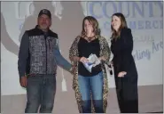  ?? CALLIE JONES — STERLING JOURNAL-ADVOCATE ?? Logan County Chamber of Commerce 2023 Board President Brianna Mcbride, right, presents the New Business of the Year Award to Darrell and Marcie Nestor, owners of The Tispy Cow, at the Chamber’s awards banquet Saturday, Feb. 25, 2023.