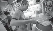  ??  ?? Hawker Lim Swee Heng prepares a bowl of laksa noodles on Aug 8.