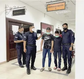  ?? ?? The young offender (third left) is escorted by police after proceeding­s in the Sessions Court.