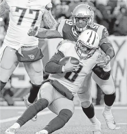  ?? Steven Senne / Associated Press ?? Patriots linebacker Marquis Flowers sacks Tennessee quarterbac­k Marcus Mariota during the second half of an NFL divisional playoff football game Saturday night in Foxborough, Mass. The Patriots set a franchise postseason record with eight sacks.