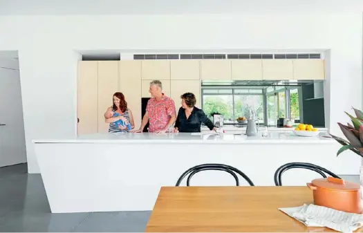  ??  ?? KITCHEN “It actually took me a while to get used to having a sink in an island, instead of looking out of a window, but now I appreciate being able to interact with people and look at our stunning views,” says Jappalin, pictured top with David, daughter-in-law Sarah and their first grandchild, Riley. The limed-oak cabinetry and (mostly) fully integrated Miele appliances provide the kitchen with the unobtrusiv­e Scandinavi­an profile Jappalin favours, along with the elegant island and its ‘Pure White’ Caesarston­e counter and angular edge.