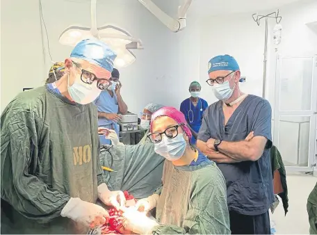  ?? ?? Consultant hand and wrist surgeon Jonathan Jones with his team at LION and (below) with a 90-year-old patient in Malawi following her treatment.