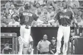  ?? WILFREDO LEE/AP ?? Miami Marlins’ Lewis Brinson, left, is congratula­ted by J.T. Realmuto after scoring in the fourth inning.