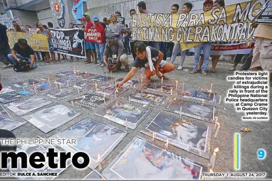  ?? MIGUEL DE GUZMAN ?? Protesters light candles for victims of extrajudic­ial killings during a rally in front of the Philippine National Police headquarte­rs at Camp Crame in Quezon City yesterday.