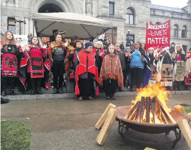  ?? AMY SMART, TIMES COLONIST ?? First Nations demonstrat­ors gather around a fire at the B.C. legislatur­e on Thursday, calling for an end to open-net fish farms. They drew about 200 supporters to their cause. The protest leaders say they’re hopeful that increasing recognitio­n of First...