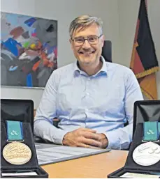  ??  ?? Heute und damals: Bürgermeis­ter Ehm mit zwei seiner Medaillen und bei den Spielen 2000.