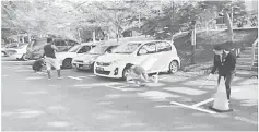  ??  ?? Staff repainting the vehicle parking bays