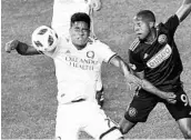  ?? DERIK HAMILTON/USA TODAY SPORTS ?? Orlando City midfielder Cristian Higuita (7) heads the ball away from Philadelph­ia Union forward Fafa Picault (9).