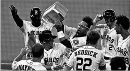  ?? BOB LEVEY/GETTY ?? Yuli Gurriel dumps ice on Astros teammate Myles Straw after his game-winning single.