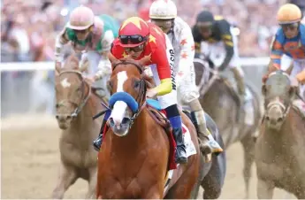  ?? MIKE STOBE/ GETTY IMAGES ?? Justify, with jockey Mike Smith, leads the field on his way to winning the Belmont Stakes.