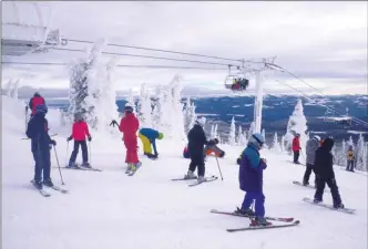  ?? J.P. SQUIRE/Special to The Okanagan Weekend ?? The top of the Black Forest Express chairlift at Big White Ski Resort was busy on Wednesday as skiers and boarders got off the high-speed quad and snowboarde­rs fastened their bindings. Only a few stopped to admire the panoramic view since they couldn't wait to descend the smooth groomed runs.