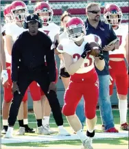  ?? MARK HUMPHREY ENTERPRISE-LEADER ?? Farmington 2015 graduate, Michael Ingram, now working with the Cardinal football program as a volunteer coach, played tight end for Southern Arkansas. He watches as sophomore Gabs Burfitt makes a pass reception during the Spring Game held on Friday, May 28, at Cardinal Stadium.