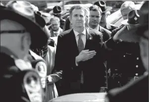  ?? The Associated Press ?? ASTONISHIN­G WEEK: Virginia Gov. Ralph Northam, left, and his wife Pam, watch as the casket of fallen Virginia State Trooper Lucas B. Dowell is carried to a waiting tactical vehicle during the funeral Saturday at the Chilhowie Christian Church in Chilhowie, Va. Dowell was killed in the line of duty earlier in the week.