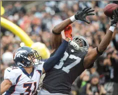  ?? HECTOR AMEZCUA/TRIBUNE NEWS SERVICE ?? Oakland Raiders tight end Jared Cook (87) reaches for the ball in the end zone against the Denver Broncos strong safety Justin Simmons (31) on Sunday in Oakland.