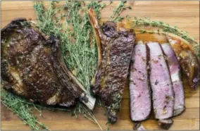  ?? SARAH CROWDER VIA AP ?? This September 2017photo shows ribeye steaks with thyme-garlic butter in NewYork. This is a classy take on a restaurant-quality steak dinner, and it’s only 30minutes from start to finish.