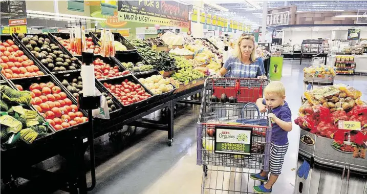  ?? Jerry Baker ?? Annalisa Jeppson and her son Tagg shop for produce at the H-E-B on Kuykendahl Road in The Woodlands. Grocers are adding locations as the area population grows.