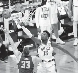  ?? JARED C. TILTON/GETTY IMAGES ?? Duke’s Mark Williams, right, attempts to block the shot of Boston College’s James Karnik during the ACC tournament. Williams, a former Norfolk Academy star, finished with 13 points.